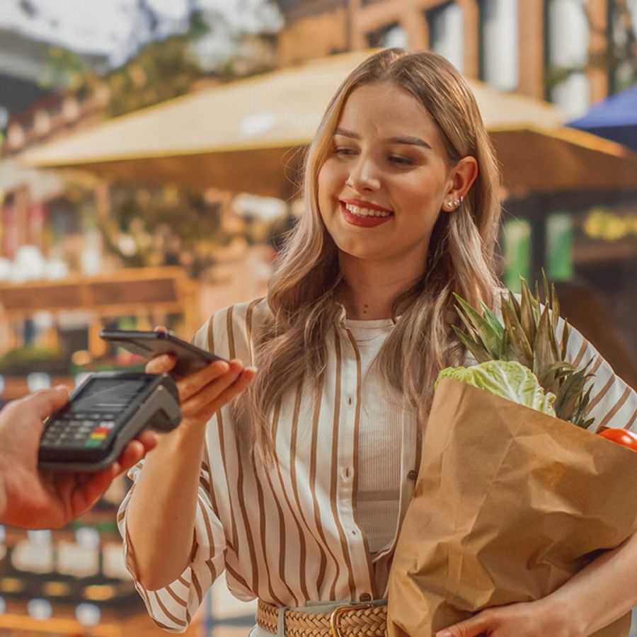 woman paying with mobile for groceries
