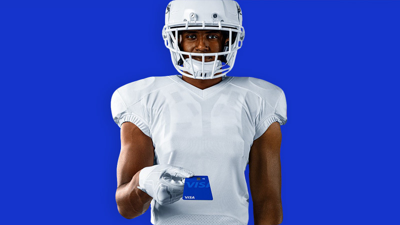 football player holding visa card