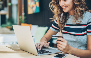 person on laptop holding a cup